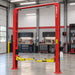 AMGO OH-12 Clear Floor Two-Post Lift installed in a professional automotive garage with clear floor design and overhead structure