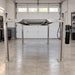 Triumph NSS-8XLT 8,000 lb Four-Post Car Lift raised inside a professional garage