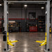 Triumph NTO-10A Overhead Two-Post Lift displayed in a dark automotive workshop